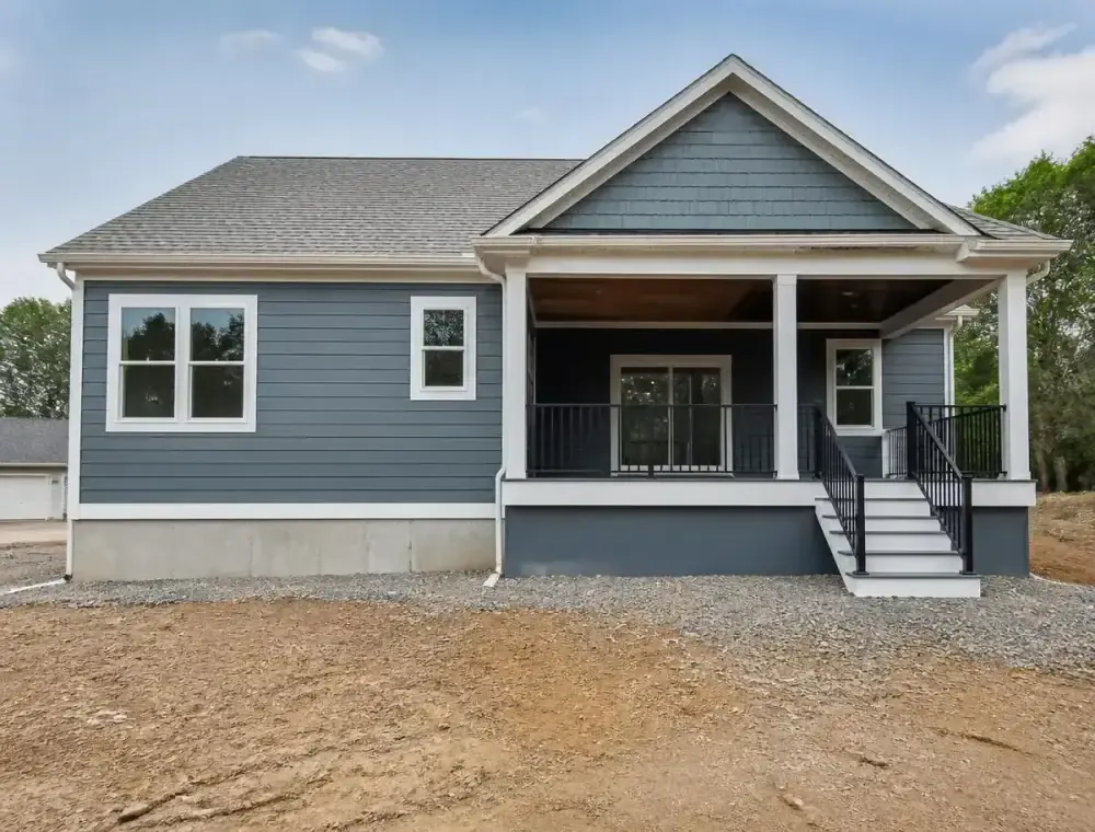 Rear exterior of a new construction home with painted porch columns and white trim