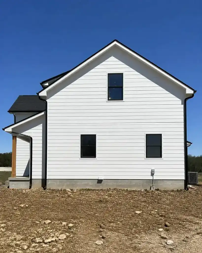 Newly constructed home with freshly painted white siding and black trim by George Harper Painting